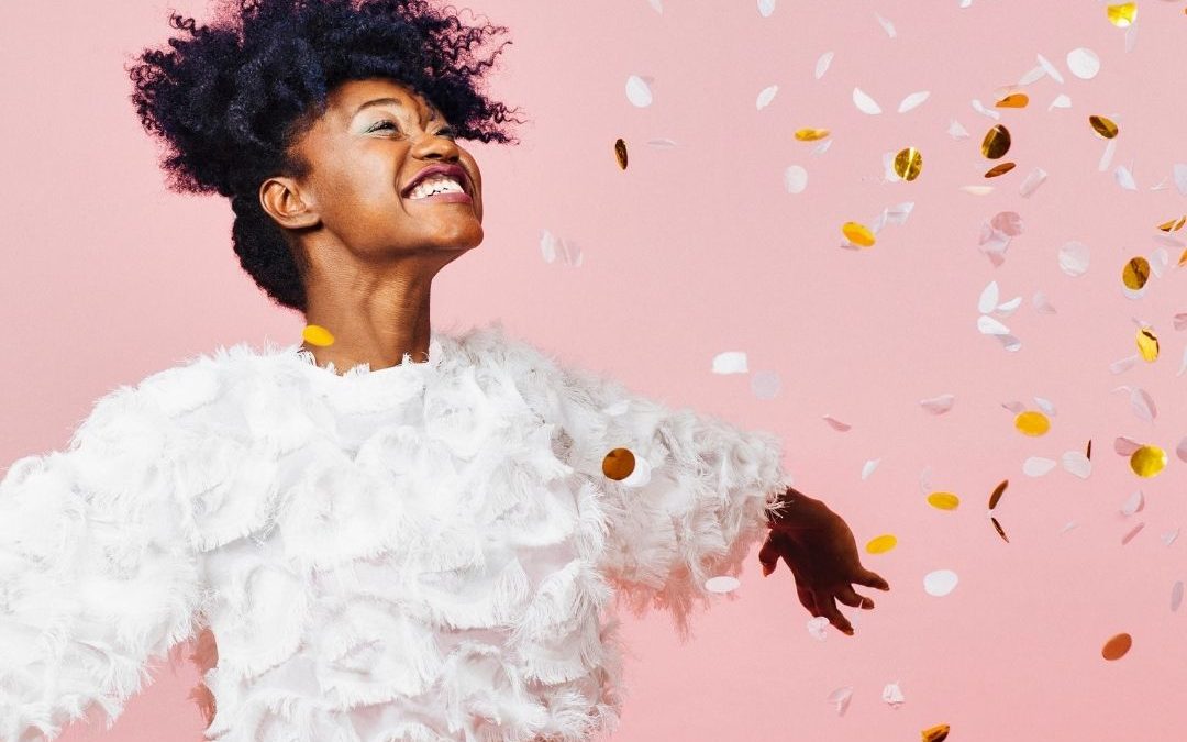 Happy Black woman celebrates year in review (from doulas)