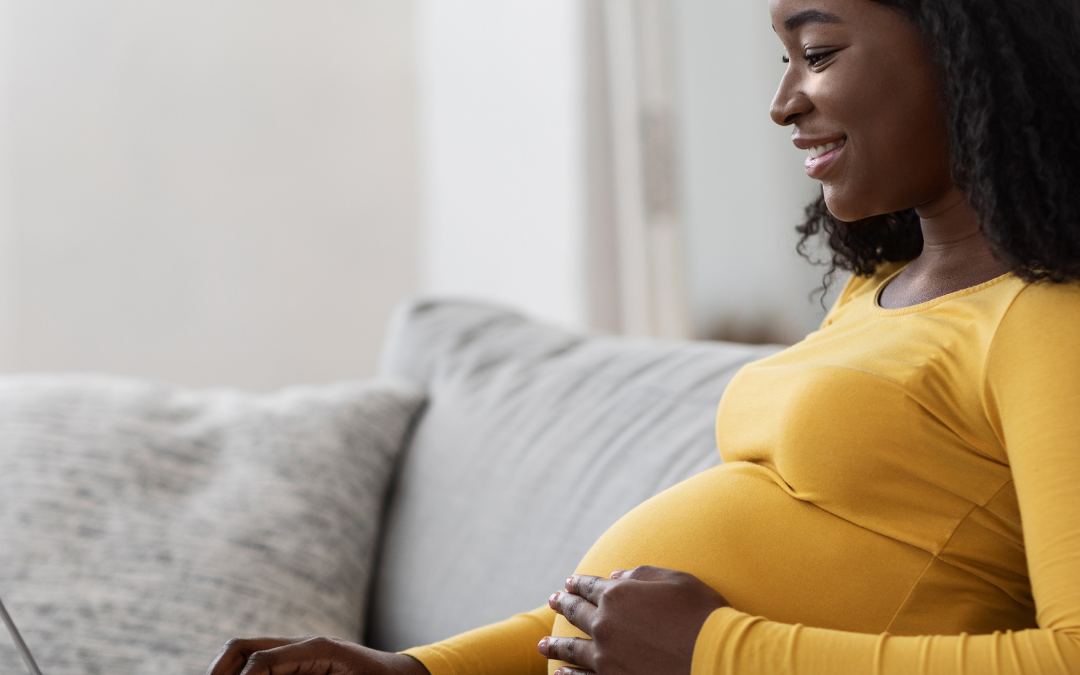 Black pregnant woman looks up information for pregnancy, postpartum, labor doulas