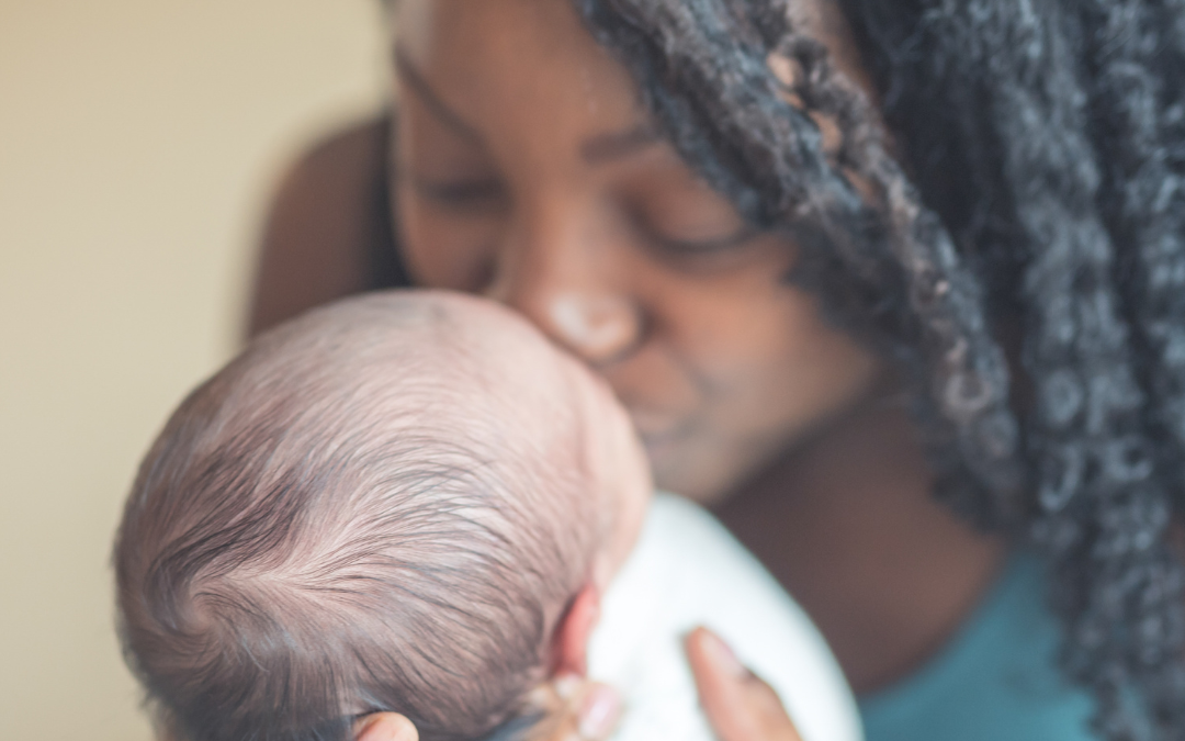 Black mother kisses newborn baby. Postpartum doula overnight