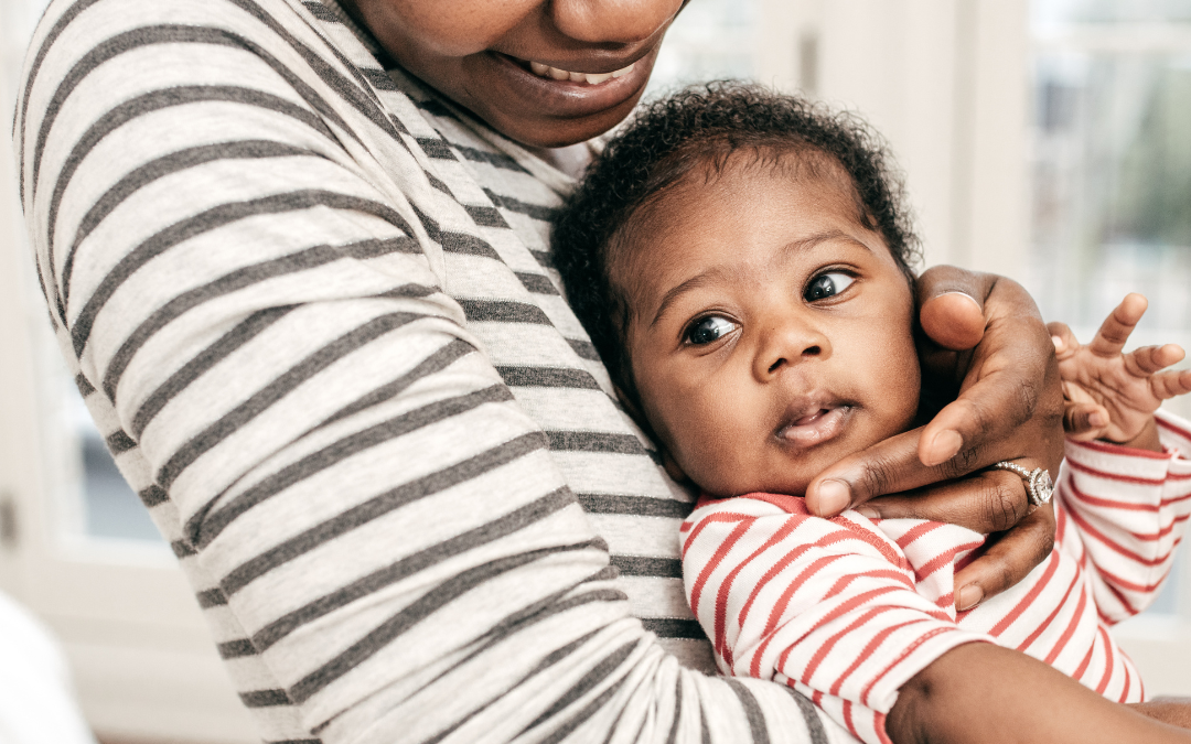 Black woman holds baby during postpartum, doula vaginal recovery
